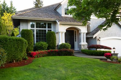 Happy homeowner with trimmed shrubs